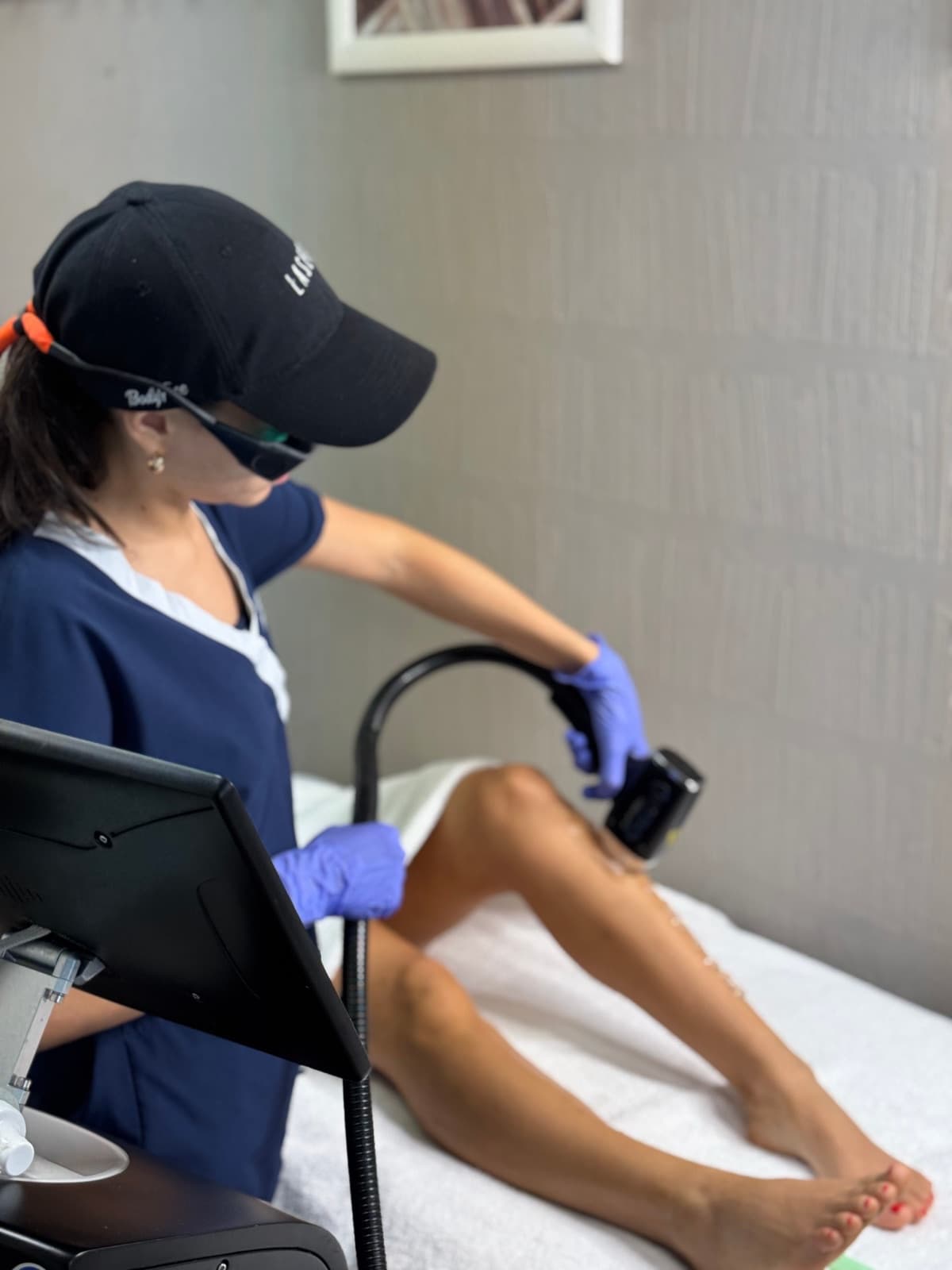 Técnica de Bodyfree con gorra y gafas de protección durante una sesión de depilación láser en la cabina de Marbella, Panamá