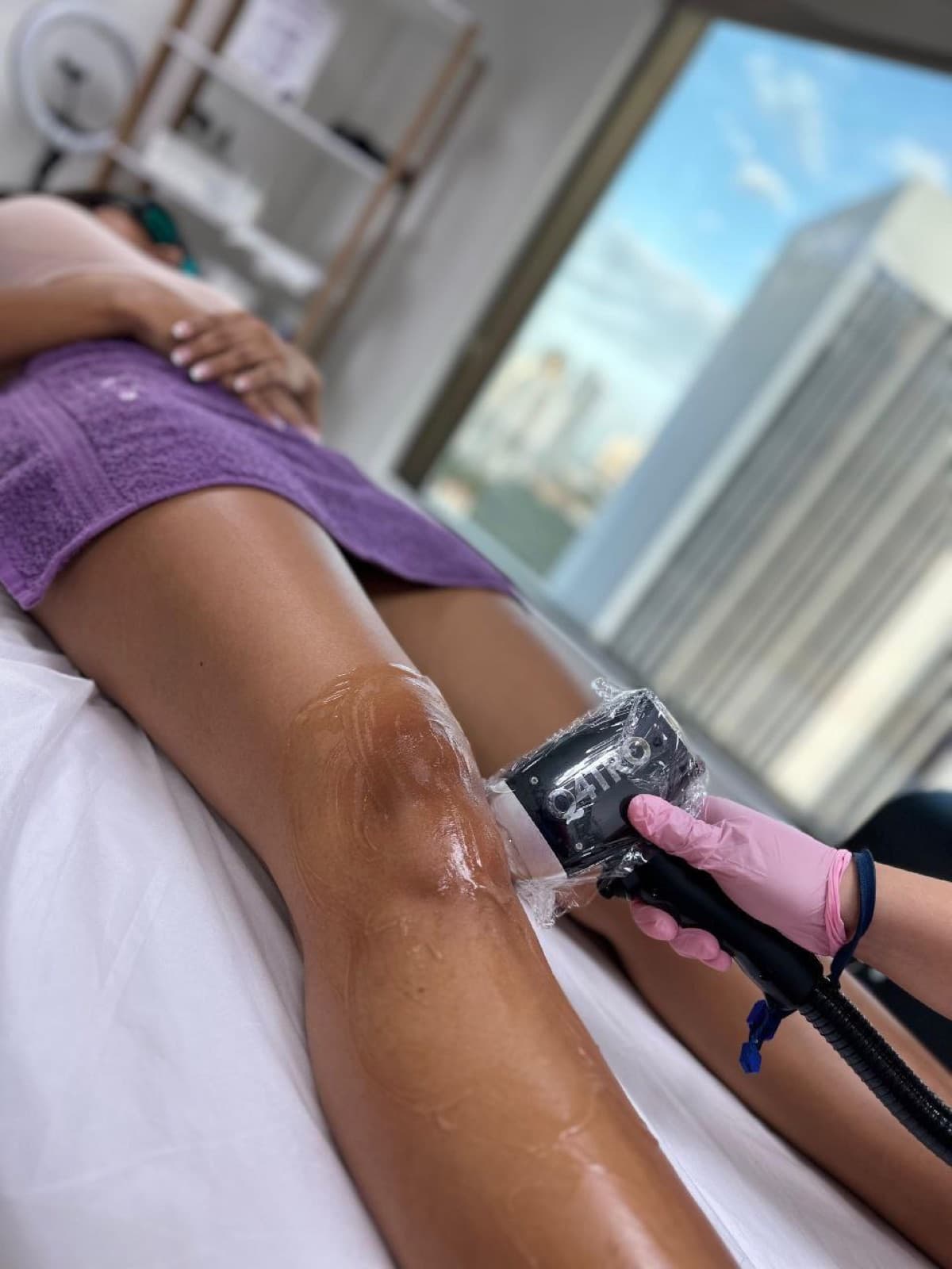 Sesión de depilación láser de muslo con Q4TRO y vista de la Ciudad de Panamá por la ventana — Bodyfree Panamá